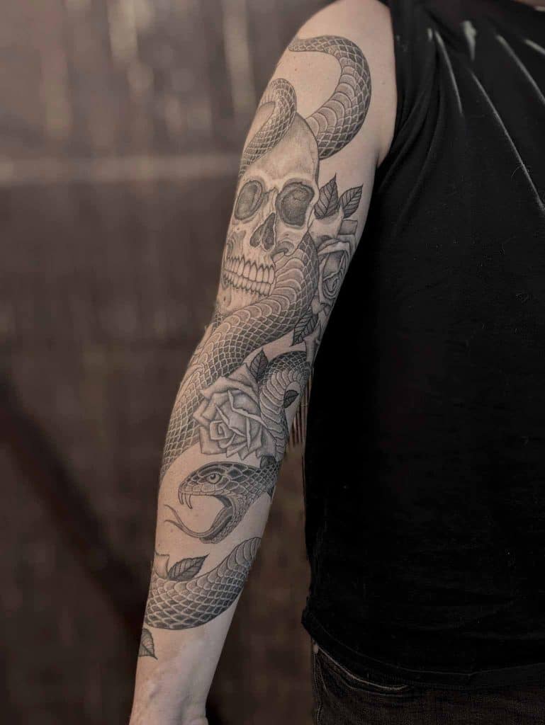 tatuaje manga serpiente calavera y rosas realizado en madrid por aitor irimia
